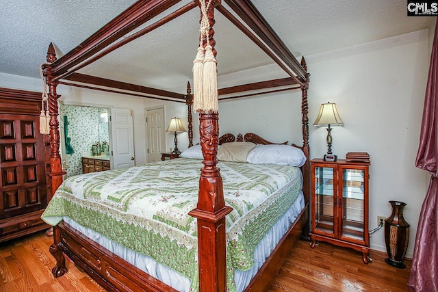 bedroom with a textured ceiling and wood finished floors