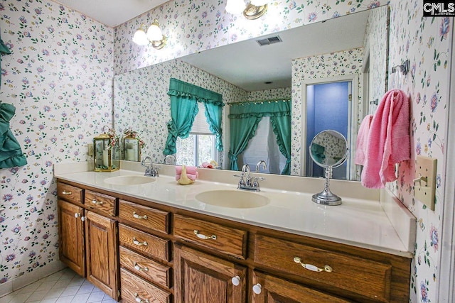 full bathroom featuring wallpapered walls, visible vents, a sink, and tile patterned floors