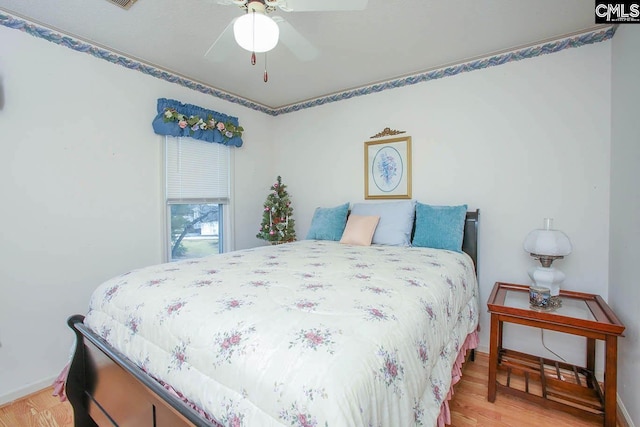 bedroom featuring a ceiling fan, light wood-style flooring, and baseboards