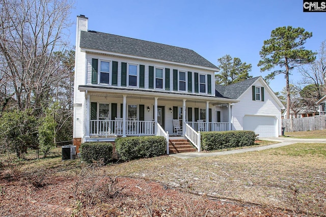 colonial home featuring a chimney, central air condition unit, a porch, fence, and a garage