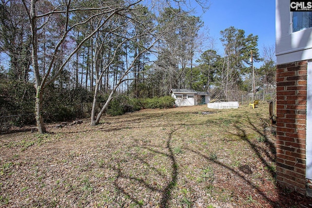 view of yard with an outbuilding, a storage shed, and fence