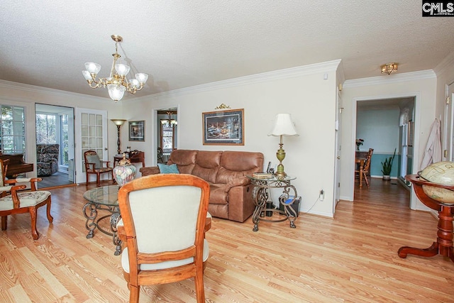 living room featuring a chandelier, light wood-type flooring, ornamental molding, and plenty of natural light