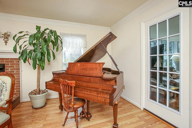 sitting room with crown molding, a textured ceiling, baseboards, and wood finished floors