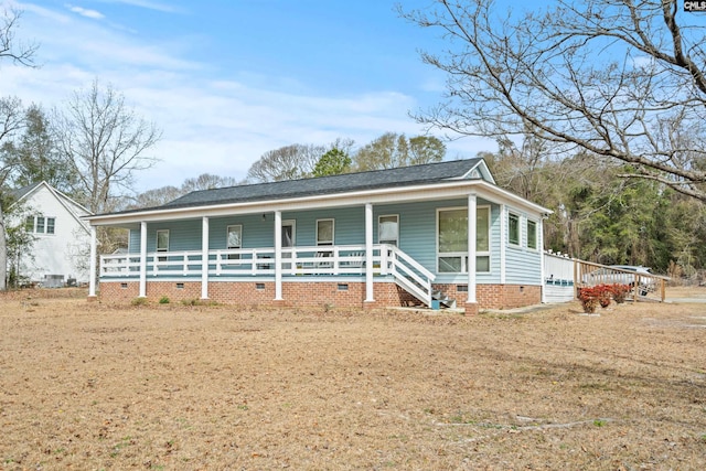 view of front of house with roof with shingles, a porch, and crawl space