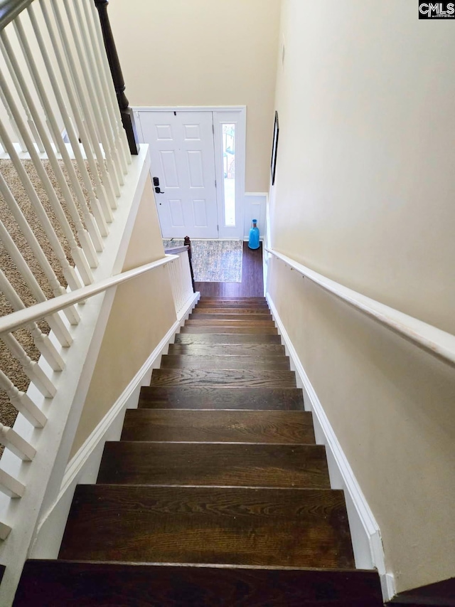 stairway featuring wainscoting and hardwood / wood-style flooring