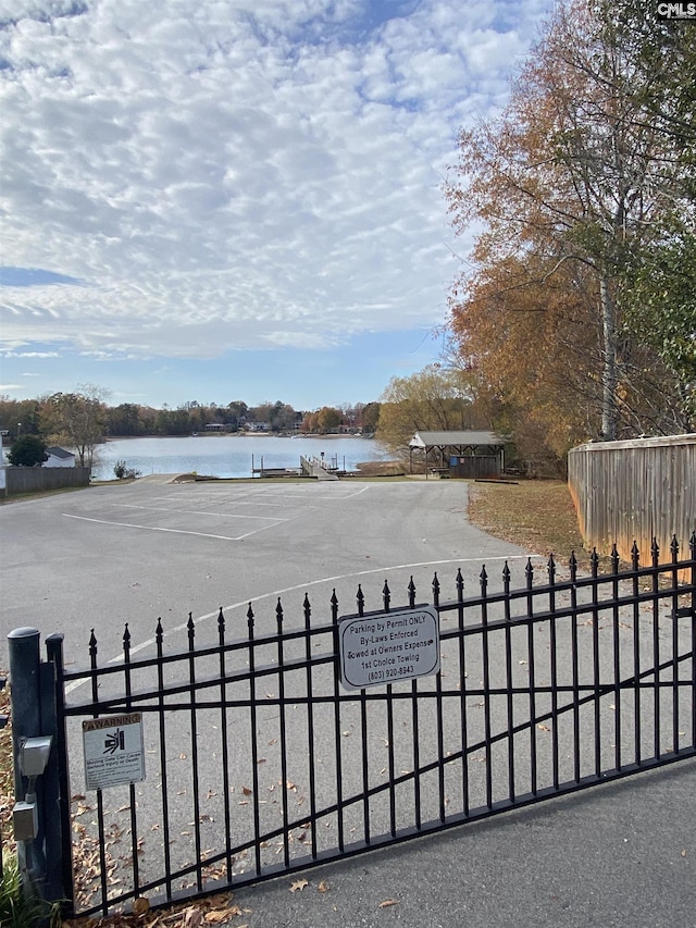 view of gate featuring a water view and fence