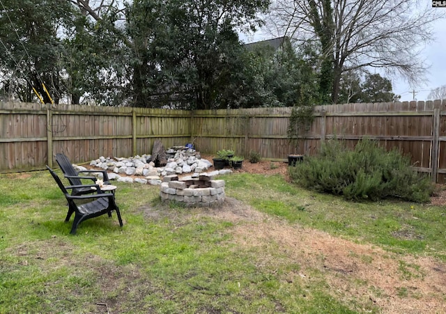 view of yard with a fenced backyard and a fire pit