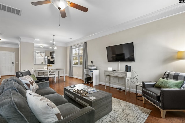 living room with visible vents, ornamental molding, wood finished floors, decorative columns, and baseboards