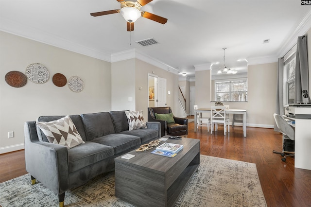 living area with baseboards, visible vents, dark wood finished floors, crown molding, and ceiling fan with notable chandelier