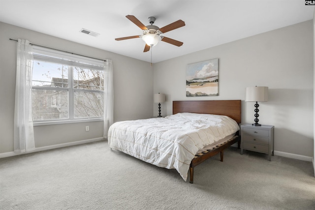 carpeted bedroom with visible vents, a ceiling fan, and baseboards