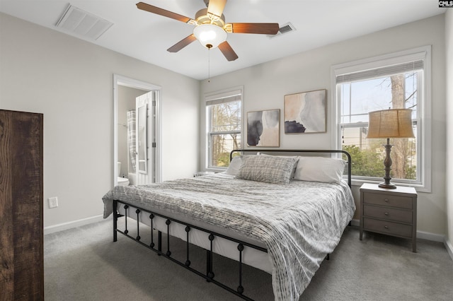 carpeted bedroom featuring visible vents, baseboards, and ensuite bathroom