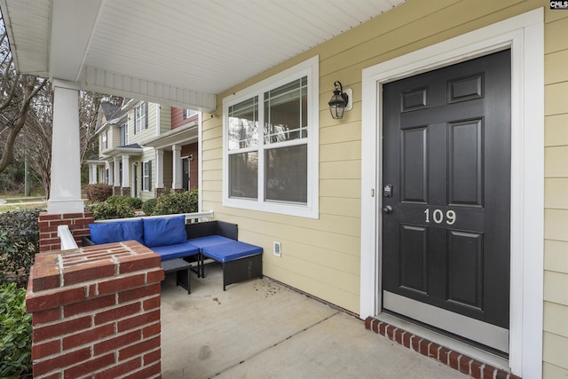 view of exterior entry featuring covered porch