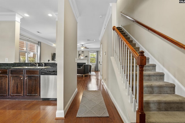 interior space featuring ceiling fan, visible vents, ornamental molding, and hardwood / wood-style flooring