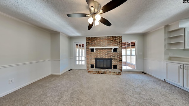 unfurnished living room with a brick fireplace, carpet flooring, crown molding, and a textured ceiling