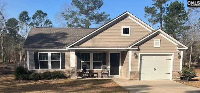 view of front facade featuring roof with shingles, a porch, concrete driveway, a garage, and stone siding