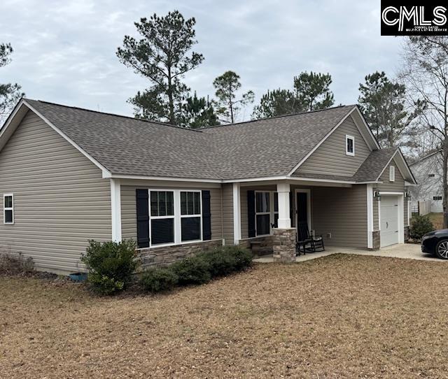 view of front of house with a garage, stone siding, and a shingled roof