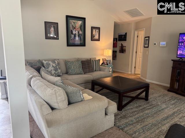 living room with baseboards, visible vents, and carpet flooring