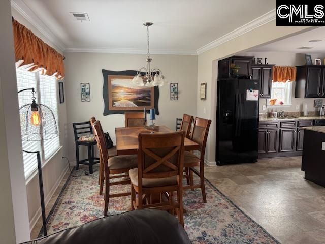 dining area with a chandelier, ornamental molding, visible vents, and baseboards