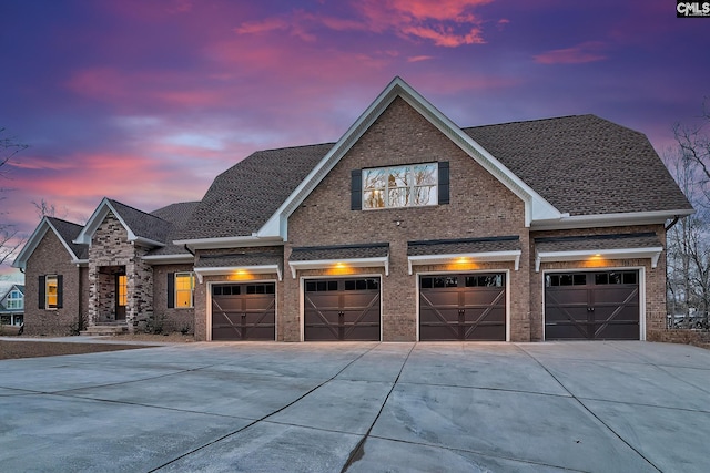 view of front of property with concrete driveway, brick siding, and roof with shingles