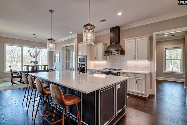 kitchen with dark wood-style flooring, stainless steel appliances, custom range hood, visible vents, and decorative backsplash