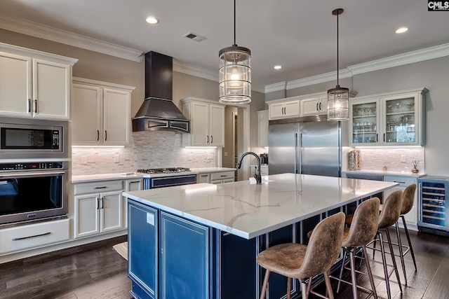 kitchen with custom exhaust hood, visible vents, a sink, built in appliances, and beverage cooler