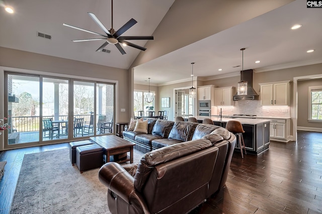 living area featuring visible vents, dark wood finished floors, a ceiling fan, crown molding, and recessed lighting