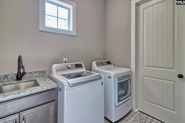 washroom featuring washer and dryer, cabinet space, and a sink