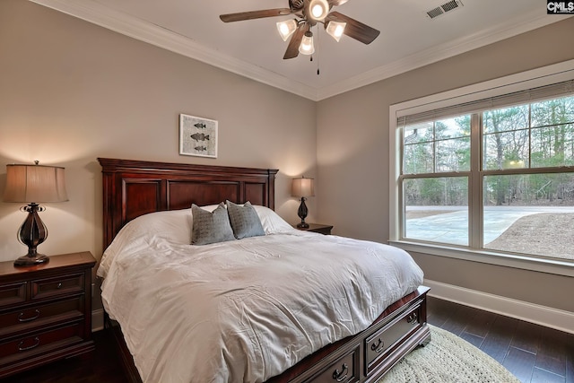 bedroom with dark wood-style floors, ornamental molding, visible vents, and baseboards