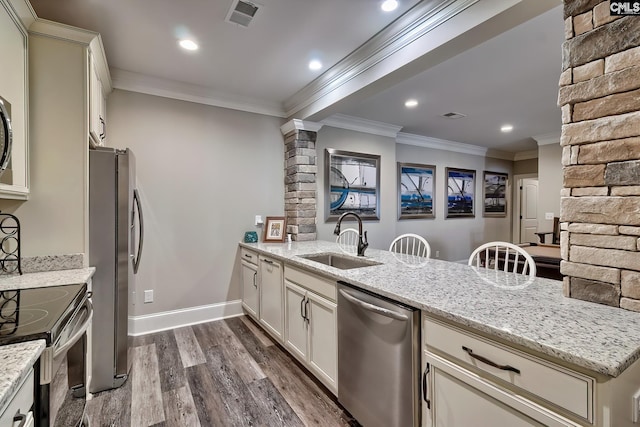 kitchen featuring visible vents, appliances with stainless steel finishes, a sink, and ornamental molding