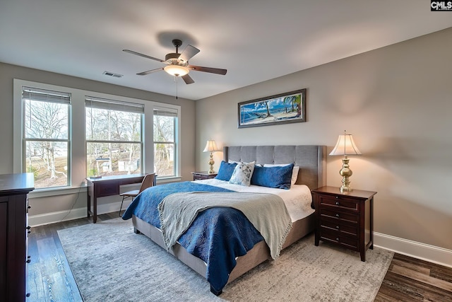 bedroom with visible vents, baseboards, and wood finished floors