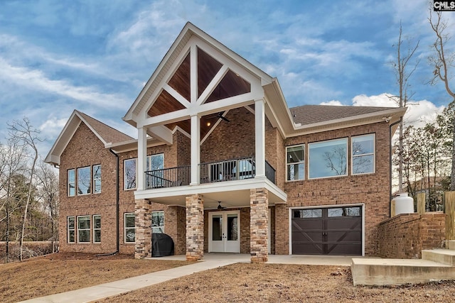 back of property featuring a balcony, roof with shingles, an attached garage, french doors, and brick siding