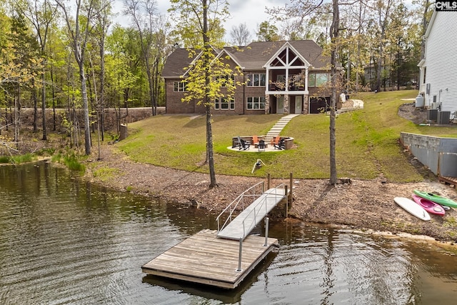 view of dock featuring a water view, a lawn, and central AC