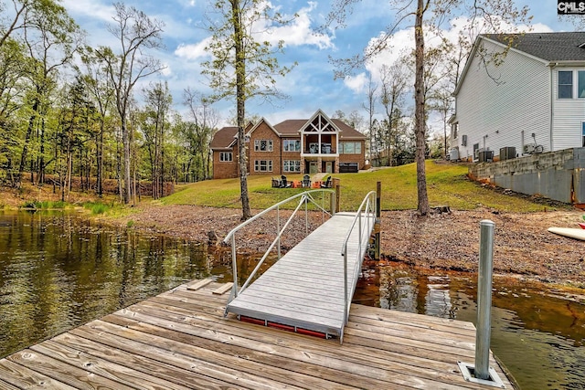 dock area with a water view and a yard