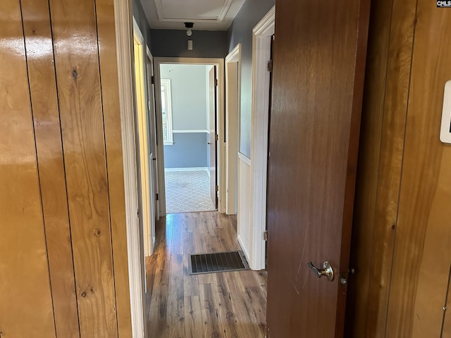 corridor featuring wood finished floors and visible vents