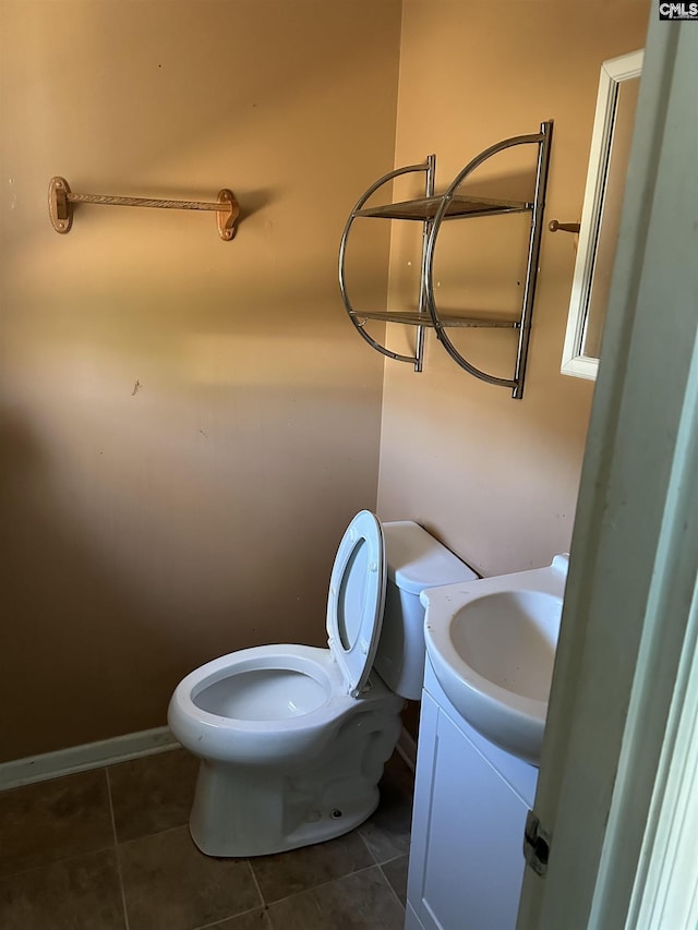 bathroom featuring baseboards, vanity, toilet, and tile patterned floors