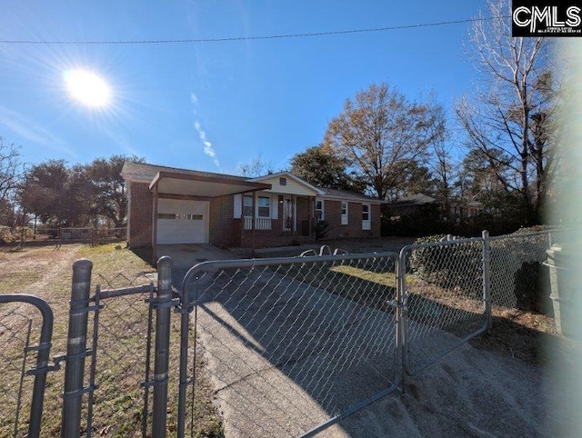 ranch-style home with a garage, driveway, a fenced front yard, a gate, and brick siding