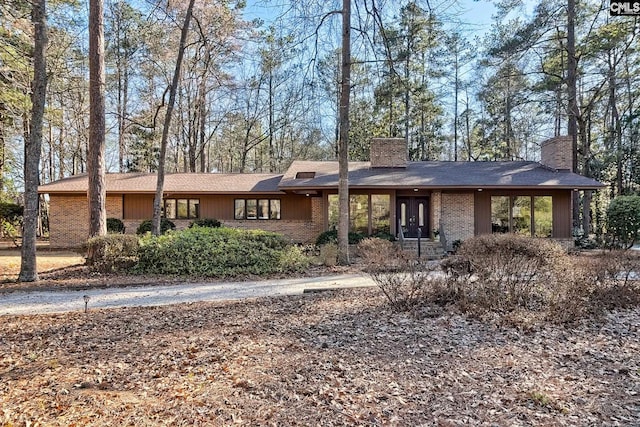 view of front of house with brick siding and a chimney