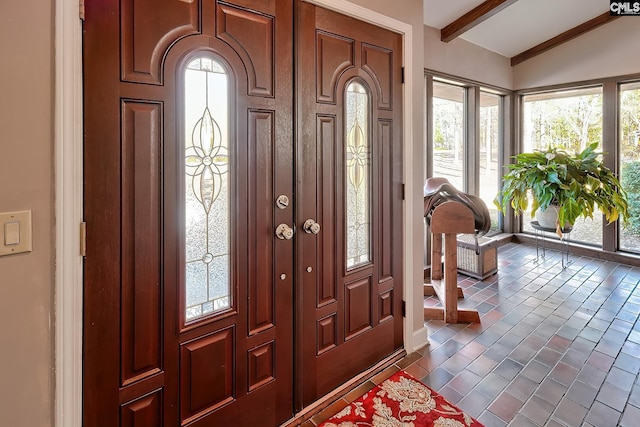 foyer entrance with lofted ceiling with beams and brick floor