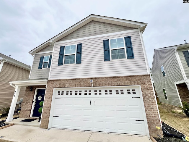 view of front of house featuring driveway, brick siding, and an attached garage