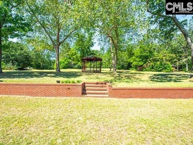 view of property's community featuring a lawn and a gazebo