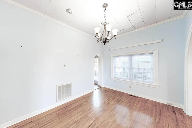 empty room with arched walkways, visible vents, and crown molding