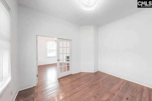 spare room featuring wood-type flooring and baseboards