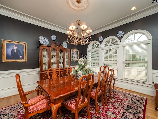 dining area with a chandelier, recessed lighting, a wainscoted wall, light wood-style floors, and crown molding