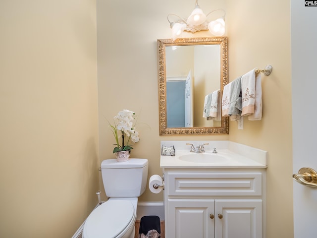 half bathroom featuring vanity and toilet