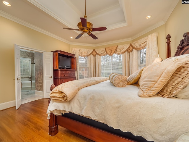 bedroom with recessed lighting, a tray ceiling, wood finished floors, and ornamental molding