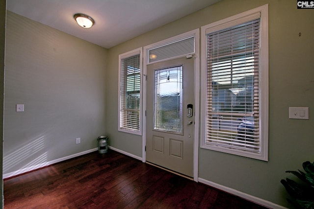 foyer featuring baseboards and wood-type flooring