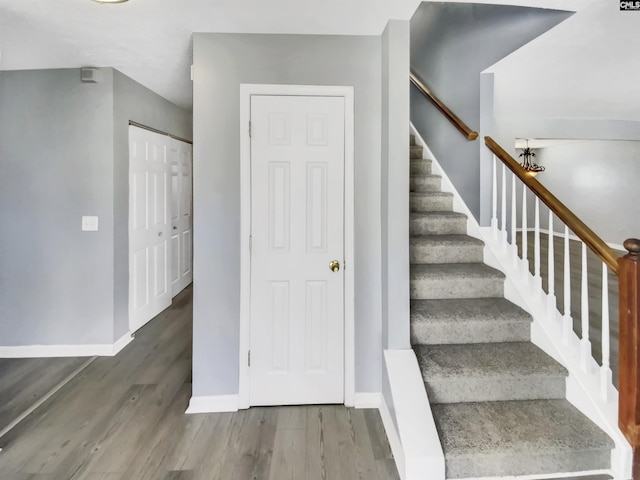 staircase featuring baseboards and wood finished floors