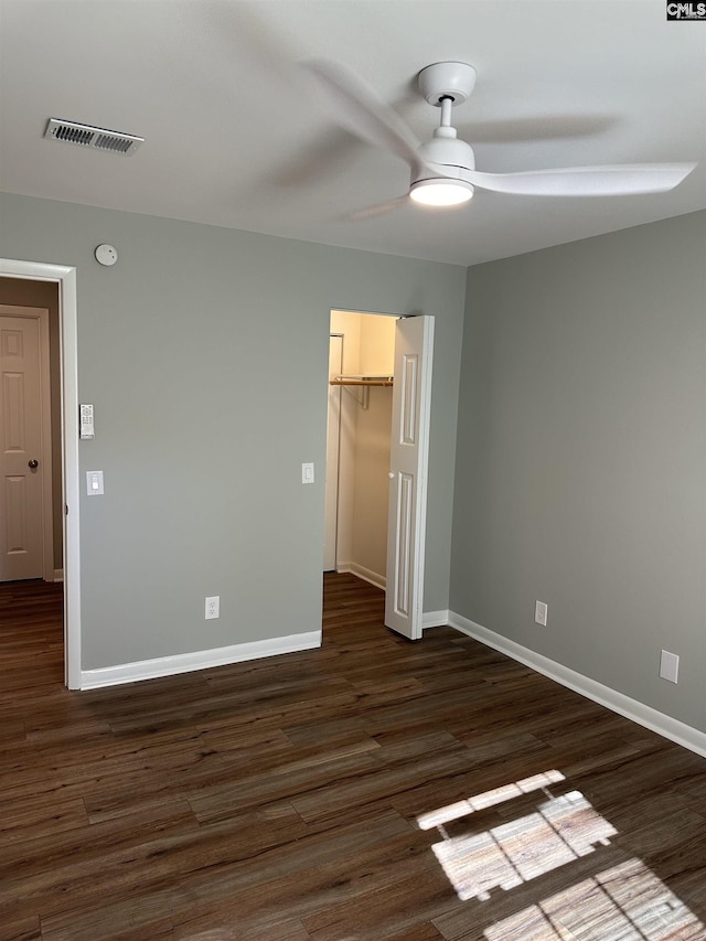 unfurnished bedroom with visible vents, baseboards, and dark wood finished floors