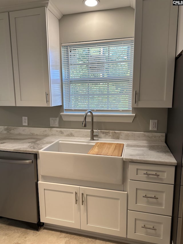 kitchen with a sink, white cabinetry, stainless steel dishwasher, and light countertops