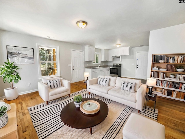 living area with visible vents, baseboards, and light wood-type flooring